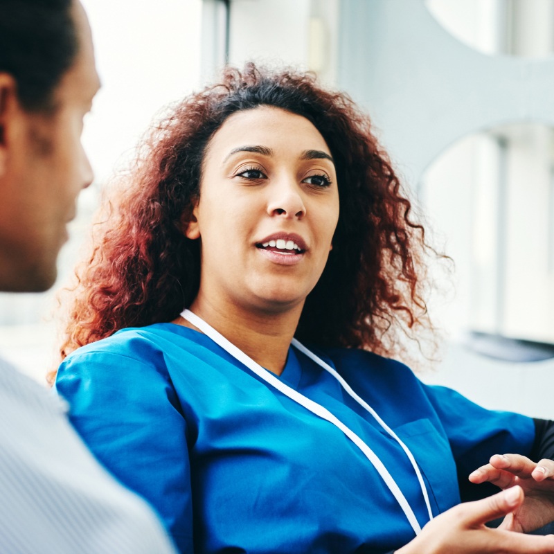 a nurse talking to a patient in a waiting room.