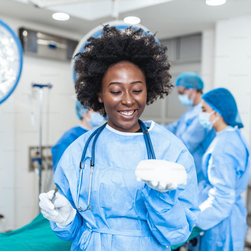 Portrait of smiling African American female surgeon in surgical uniform at operating room.